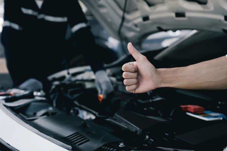 Thumbs up as an expert car mechanic performs a safety inspection