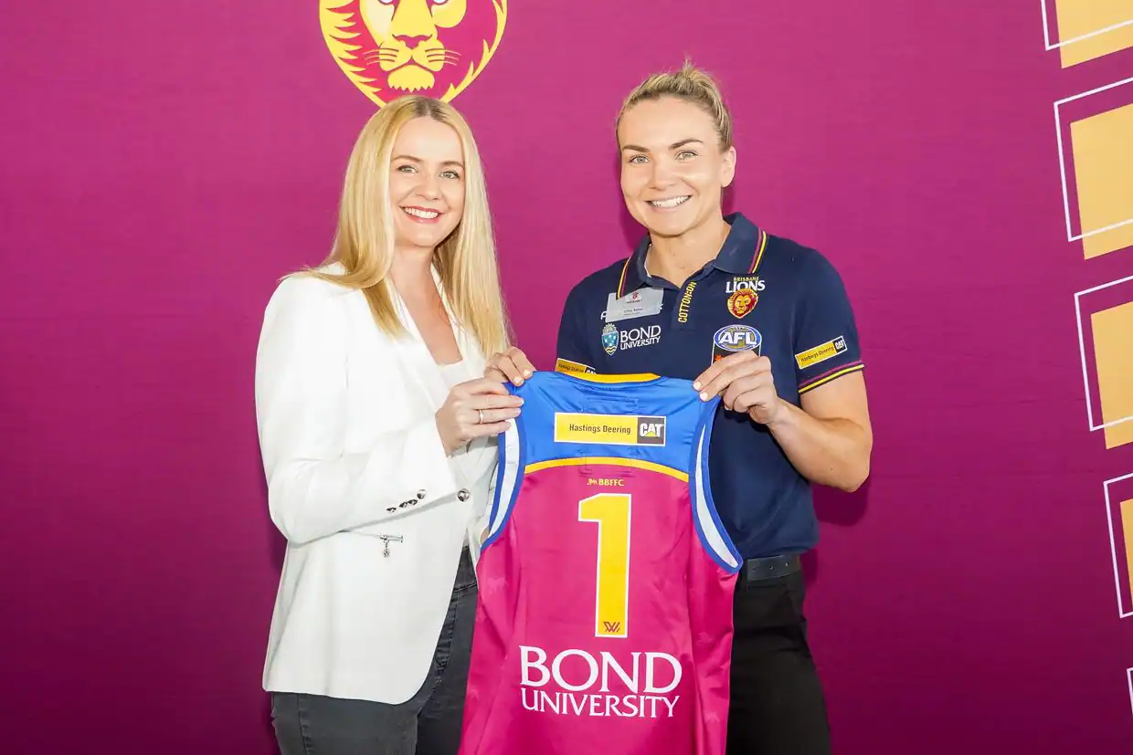 A phot of Anne from Coleman Tyres & Mechanical in Wacol and Emily Bates from Brisbane Lions AFLW team holding the Number 1 guernsey