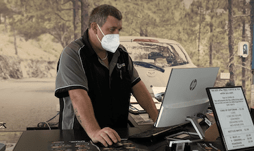A masked Coleman Tyres employee using a computer in reception