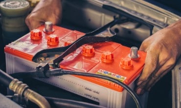 Hands removing a car battery