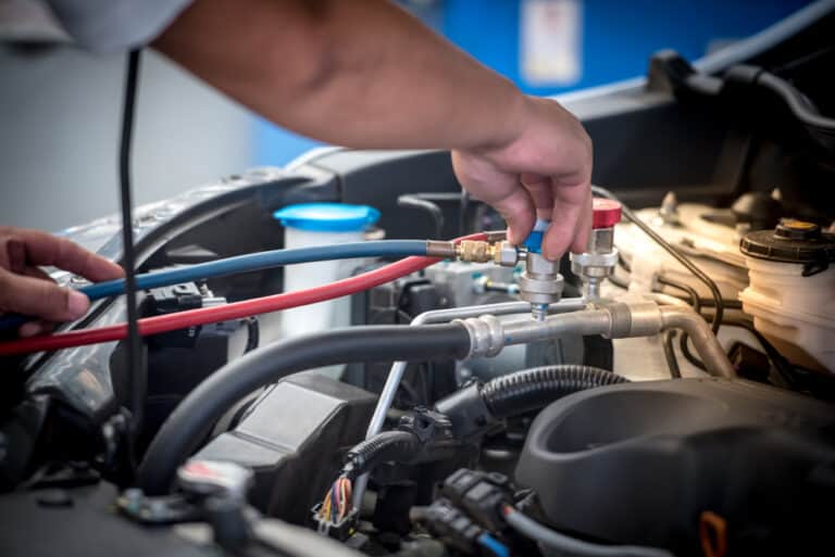 A Coleman Tyres and Mechanical mechanic performing a quality air-conditioning regas service on a car for a client