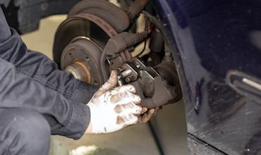 A mechanic servicing car brakes