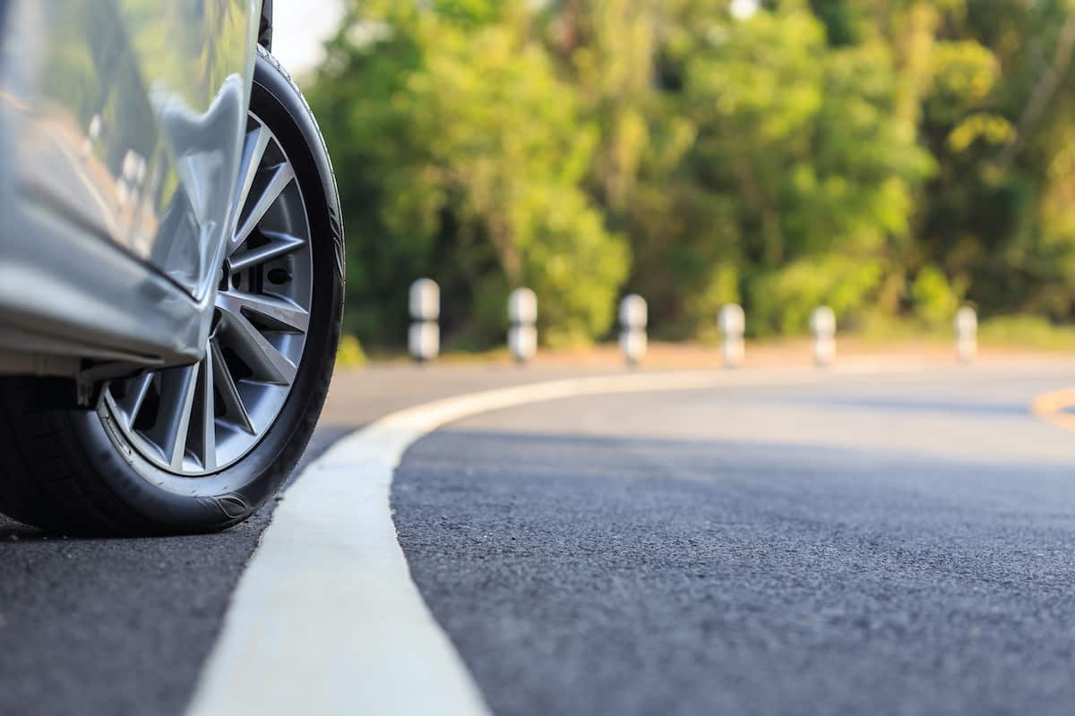Close up of a front wheel turning on a road