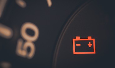 A close up shot a dashboard showing a lit ip battery icon