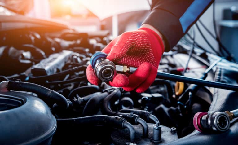 A Coleman Tyres & Mechanical Wacol mechanic conducting an air-conditioning regas service on a client's car